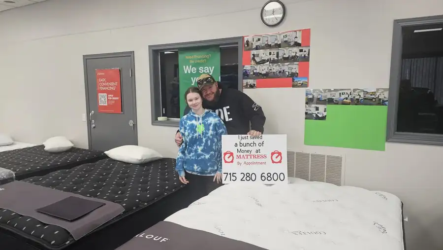 Happy customers trying a mattress at Mattress by Appointment Wausau